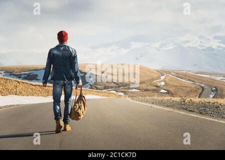 Un élégant boxeur à dos rétro et à dos de soleil fait une promenade sur la route asphaltée par une journée ensoleillée. Le concept de hitc Banque D'Images