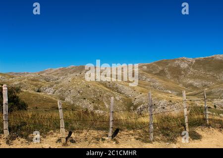 Belle vue sur les collines de montagne. Ancienne clôture bosniaque en piquets en bois et fil barbelé. Couper le fil cannelé. Bjelasnica Mountain, Bosnie-Herzégovine Banque D'Images