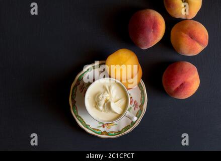 Ensemble et tranches de pêches et crème sur tableau noir - Haut Voir photo Banque D'Images