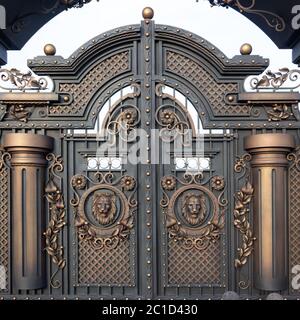 Nouvelles portes massives en métal forgé avec une porte et deux arches, gris doré, fabriquées dans l'antiquité. Banque D'Images