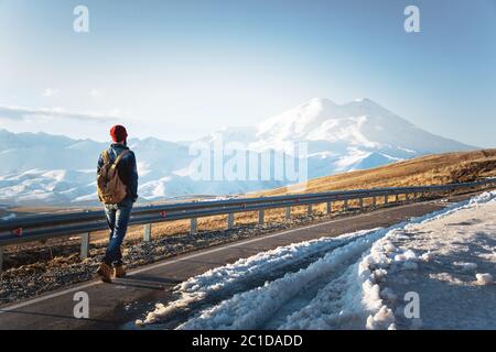 Un élégant boxeur à dos rétro et à dos de soleil fait une promenade sur la route asphaltée par une journée ensoleillée. Le concept de hitc Banque D'Images