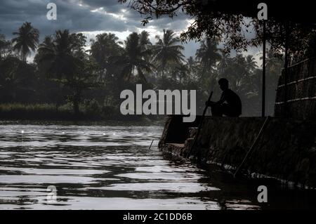 Une vue panoramique d'un homme assis près des eaux profondes situé dans la ville d'Allepey, dans l'état de Kerala, en Inde Banque D'Images