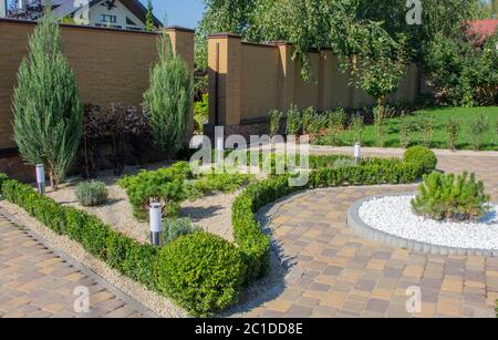 Piste pavée en béton pavée dans un jardin magnifiquement entretenu Banque D'Images