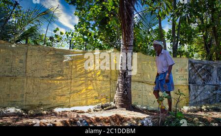 Kerala, Inde - 11 mars 2014 : un pêcheur marchant dans une rue à côté des eaux de l'Allepey situé dans l'État de Kerala, Inde Banque D'Images