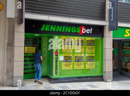 Bracknell, Berkshire, Royaume-Uni. 15 juin 2020. Un homme entre dans les livres Jennings Bet. Les magasins non essentiels étaient occupés à l'ouverture ce matin au centre commercial Lexicon à Bracknell, dans le Berkshire, pour la première fois depuis le confinement pandémique du coronavirus Covid-19. Des mesures de distance sociale étaient en place, notamment un système à sens unique pour les acheteurs. Crédit : Maureen McLean/Alay Banque D'Images