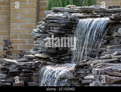 fontaine avec deux débordements, dans un style ancien. Utilisant des matériaux naturels tels que le marbre sauvage, l'ardoise, le granit et le basalte Banque D'Images