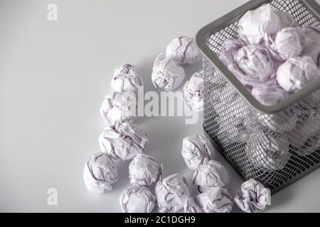 Un trashcan plein de papier froissé sur fond blanc gros plan Banque D'Images