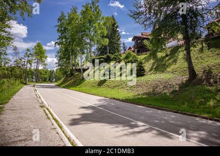 Lac Vlasina, Serbie - juin 14. 2020 route de campagne et maisons en bois et une grande cour avec des pins et des bouleaux lors d'une journée ensoleillée d'été dans le village Banque D'Images