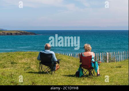 Inchydoney, West Cork, Irlande. 15 juin 2020. La plage d'Inchydoney à West Cork était aujourd'hui remplie de gens de plage, ce qui a fait le maximum du soleil et de la chaleur. Un couple se détend tout en regardant la mer. Crédit : AG News/Alay Live News Banque D'Images