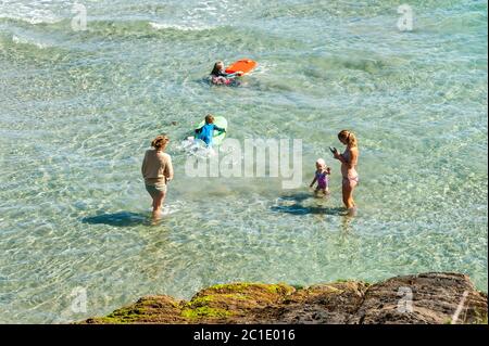 Inchydoney, West Cork, Irlande. 15 juin 2020. La plage d'Inchydoney à West Cork était aujourd'hui remplie de gens de plage, ce qui a fait le maximum du soleil et de la chaleur. Une famille joue dans l'eau. Crédit : AG News/Alay Live News Banque D'Images