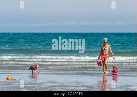 Inchydoney, West Cork, Irlande. 15 juin 2020. La plage d'Inchydoney à West Cork était aujourd'hui remplie de gens de plage, ce qui a fait le maximum du soleil et de la chaleur. Une famille joue dans l'eau. Crédit : AG News/Alay Live News Banque D'Images