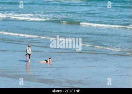 Inchydoney, West Cork, Irlande. 15 juin 2020. La plage d'Inchydoney à West Cork était aujourd'hui remplie de gens de plage, ce qui a fait le maximum du soleil et de la chaleur. Une famille joue dans l'eau. Crédit : AG News/Alay Live News Banque D'Images