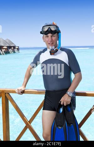 Jeune homme sportif avec palmes, masque et tube près de la mer. Les Maldives. Banque D'Images