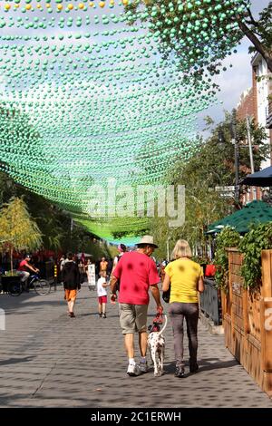 Couple chien de marche dans le village gay, Montréal, Canada sous la décoration colorée. Banque D'Images