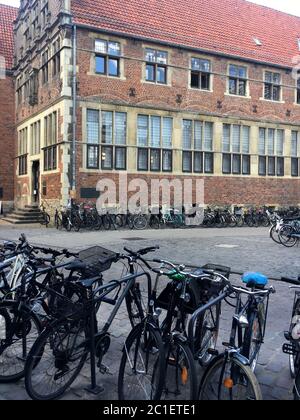 L'ancienne maison de guilde et le bâtiment de la WWU Haus der Niederlande/ Krameramtshaus à Muenster, Allemagne avec beaucoup de vélos garés en face. Banque D'Images