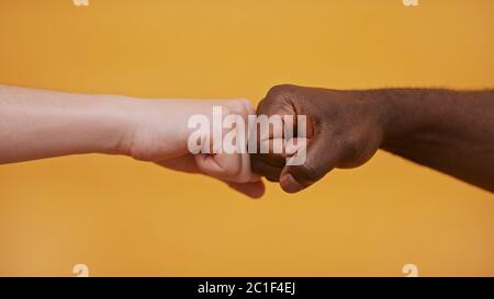 Poing vers poing - mains noires et blanches - concept de partenariat et de solidarité. Photo de haute qualité Banque D'Images
