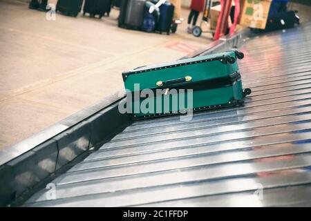 Valise sur le tapis transporteur à bagages dans la zone de retrait des bagages du terminal de l'aéroport Banque D'Images