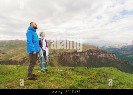 Une paire de touristes hippster se tient à côté dans les montagnes sur fond de plateau des vallées et de sk Banque D'Images