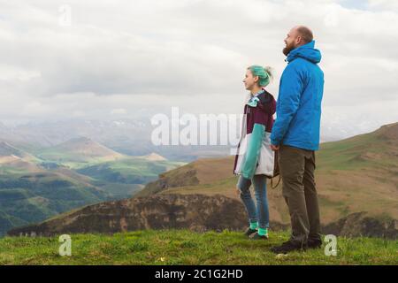 Une paire de touristes hippster se tient à côté dans les montagnes sur fond de plateau des vallées et de sk Banque D'Images