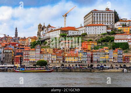 Porto, Portugal - 30 mai 2018 : vue sur le Douro sur les façades de maisons traditionnelles avec des carreaux azulejo à Ribeira et des bateaux rabelo touristiques Banque D'Images