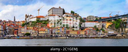 Porto, Portugal - 30 mai 2018 : vue panoramique sur les façades de maisons traditionnelles avec carreaux azulejo à Ribeira et bateaux rabelo touristiques à travers Douro Banque D'Images