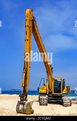 Pelle hydraulique jaune sur sable Banque D'Images