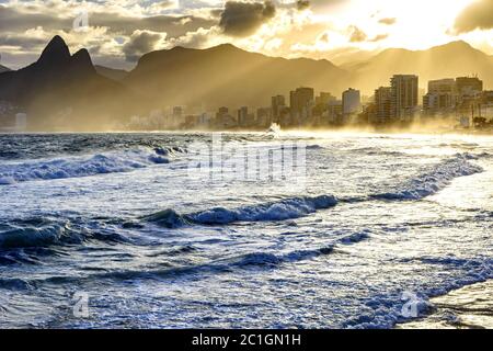 Coucher de soleil nuageux sur la plage d'Ipanema avec des rayons légers Banque D'Images