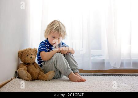 Enfant, tout-petit garçon, puni dans le coin pour avoir fait des faux-grilles Banque D'Images