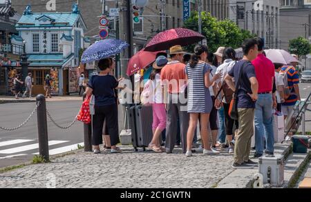 Touristes et locaux dans la rue de la ville d'Otaru, Hokkaido, Japon Banque D'Images