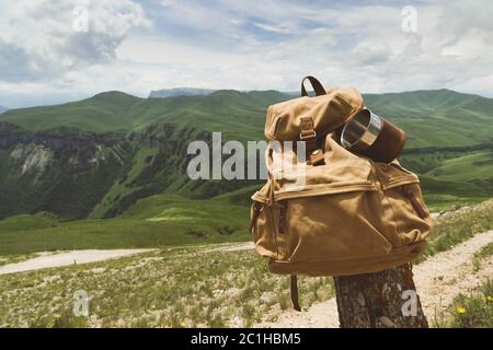 Sac à dos rétro jaune taille basse avec une tasse fixée sur elle et une vue rapprochée sur le devant. Sac de voyage du voyageur en arrière-plan o Banque D'Images