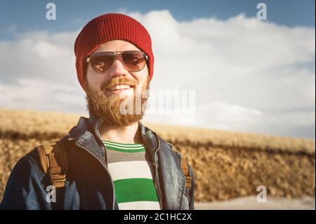 Portrait d'un jeune homme taille basse portant des lunettes de soleil et un chapeau. Un homme barbu souriant portant des lunettes de soleil. Un homme heureux avec une barbe Banque D'Images