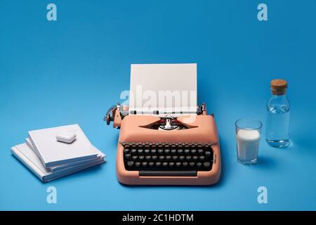 Composition avec machine à écrire, livres, verre et bouteille Banque D'Images