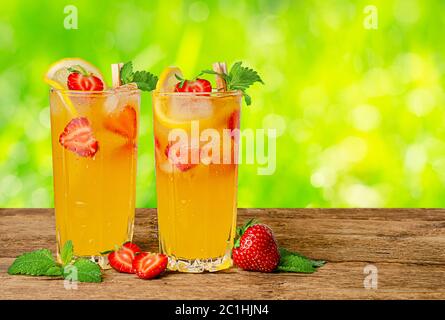 Limonade à l'orange avec fraises fraîches et menthe sur fond d'été. Copier l'espace Banque D'Images