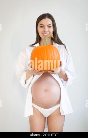 Femme enceinte avec une grande citrouille. Concept sain Banque D'Images