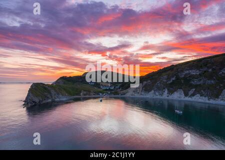 Lulworth Cove, Dorset, Royaume-Uni. 15 juin 2020. Météo Royaume-Uni. Un coucher de soleil spectaculaire à Lulworth Cove dans Dorset avec les nuages deviennent rouges à la fin d'une chaude journée ensoleillée. Crédit photo : Graham Hunt/Alay Live News Banque D'Images