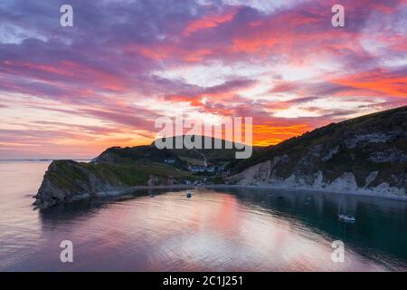 Lulworth Cove, Dorset, Royaume-Uni. 15 juin 2020. Météo Royaume-Uni. Un coucher de soleil spectaculaire à Lulworth Cove dans Dorset avec les nuages deviennent rouges à la fin d'une chaude journée ensoleillée. Crédit photo : Graham Hunt/Alay Live News Banque D'Images