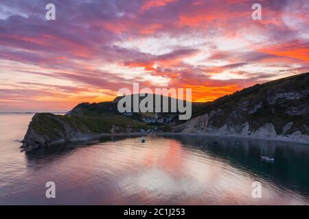 Lulworth Cove, Dorset, Royaume-Uni. 15 juin 2020. Météo Royaume-Uni. Un coucher de soleil spectaculaire à Lulworth Cove dans Dorset avec les nuages deviennent rouges à la fin d'une chaude journée ensoleillée. Crédit photo : Graham Hunt/Alay Live News Banque D'Images