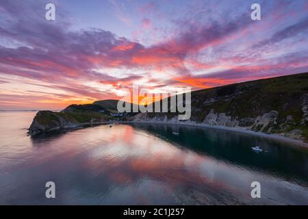 Lulworth Cove, Dorset, Royaume-Uni. 15 juin 2020. Météo Royaume-Uni. Un coucher de soleil spectaculaire à Lulworth Cove dans Dorset avec les nuages deviennent rouges à la fin d'une chaude journée ensoleillée. Crédit photo : Graham Hunt/Alay Live News Banque D'Images