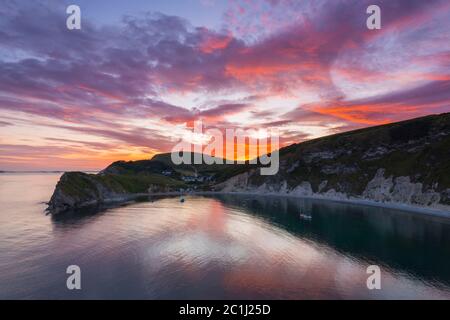 Lulworth Cove, Dorset, Royaume-Uni. 15 juin 2020. Météo Royaume-Uni. Un coucher de soleil spectaculaire à Lulworth Cove dans Dorset avec les nuages deviennent rouges à la fin d'une chaude journée ensoleillée. Crédit photo : Graham Hunt/Alay Live News Banque D'Images