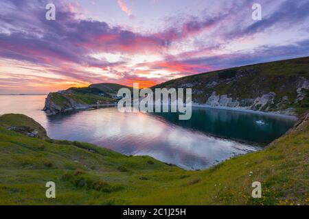 Lulworth Cove, Dorset, Royaume-Uni. 15 juin 2020. Météo Royaume-Uni. Un coucher de soleil spectaculaire à Lulworth Cove dans Dorset avec les nuages deviennent rouges à la fin d'une chaude journée ensoleillée. Crédit photo : Graham Hunt/Alay Live News Banque D'Images