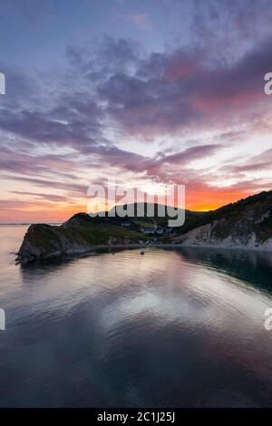 Lulworth Cove, Dorset, Royaume-Uni. 15 juin 2020. Météo Royaume-Uni. Un coucher de soleil spectaculaire à Lulworth Cove dans Dorset avec les nuages deviennent rouges à la fin d'une chaude journée ensoleillée. Crédit photo : Graham Hunt/Alay Live News Banque D'Images