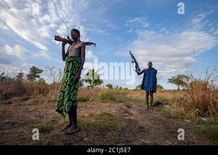 Deux hommes tribaux de la tribu Mursi dans la vallée d'Omo, en Éthiopie les deux hommes portent des vêtements indigènes et portent des mitrailleuses utilisées pour protéger les animaux. Banque D'Images