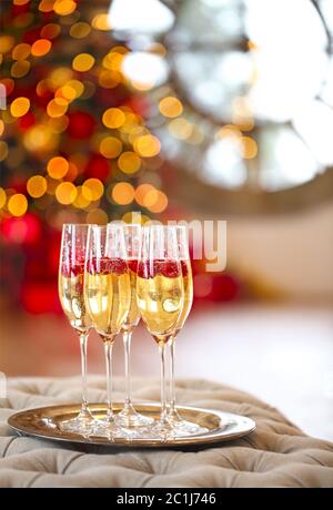 Verres de champagne avec framboise sur le cadeau près de l'arbre de Noël sur fond Banque D'Images