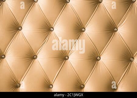 Fond textile beige doux avec boutons symétriques sur les coins des diamants. Éléments de mobilier doux et coûteux. Luxe Banque D'Images