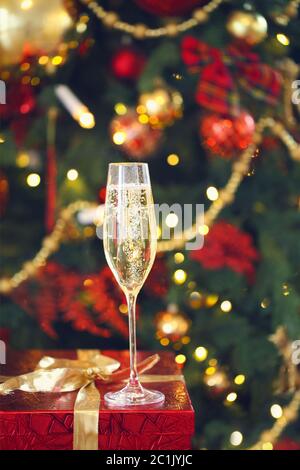 Verre de champagne sur le cadeau près de l'arbre de Noël sur fond Banque D'Images