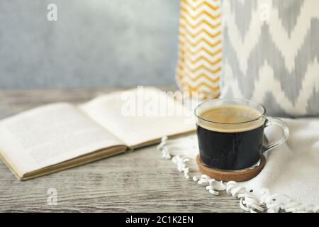 Tasse de café restant près du livre sur la table en bois Banque D'Images