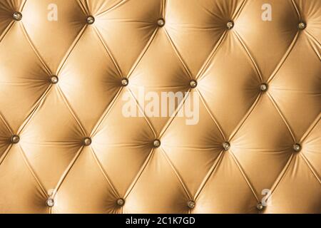 Fond textile beige doux avec boutons symétriques sur les coins des diamants. Éléments de mobilier doux et coûteux. Luxe Banque D'Images
