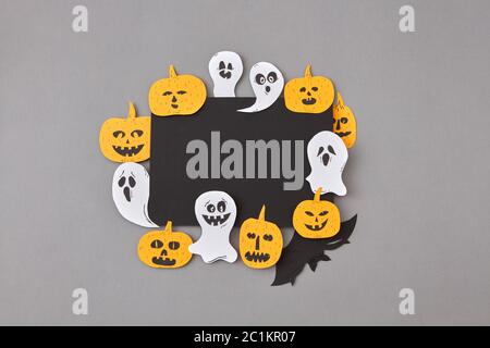 Halloween party carte fait main de rire battant fantômes, esprits, citrouilles et chauves-souris autour d'elle sur un fond gris. Banque D'Images