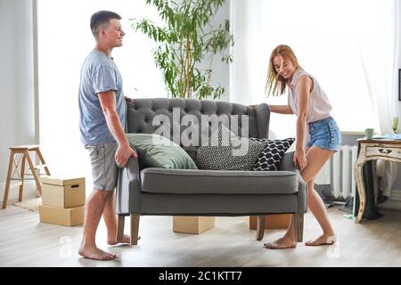 Jeune couple heureux dans la chambre avec les boîtes de déménagement à new home Banque D'Images