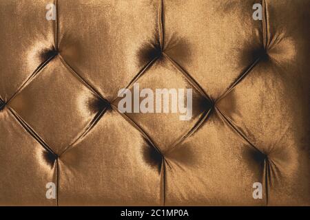 Fond textile beige doux avec boutons symétriques sur les coins des diamants. Éléments de mobilier doux et coûteux. Luxe Banque D'Images